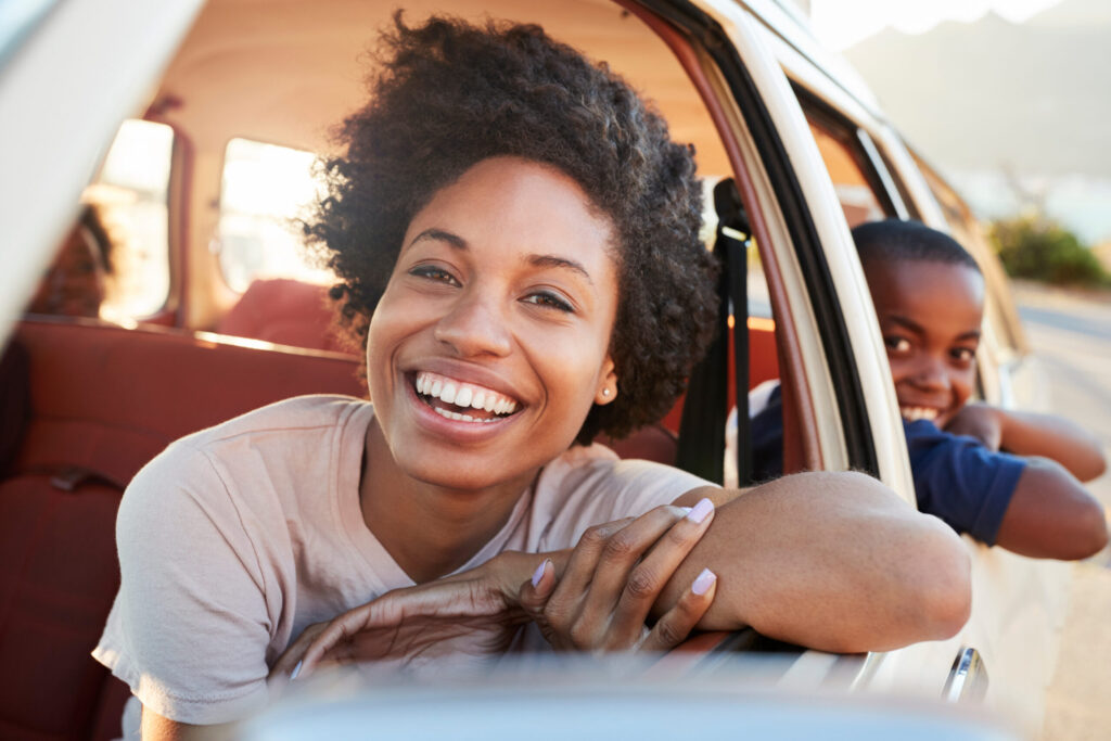 portrait of mother and children relaxing in car during road trip